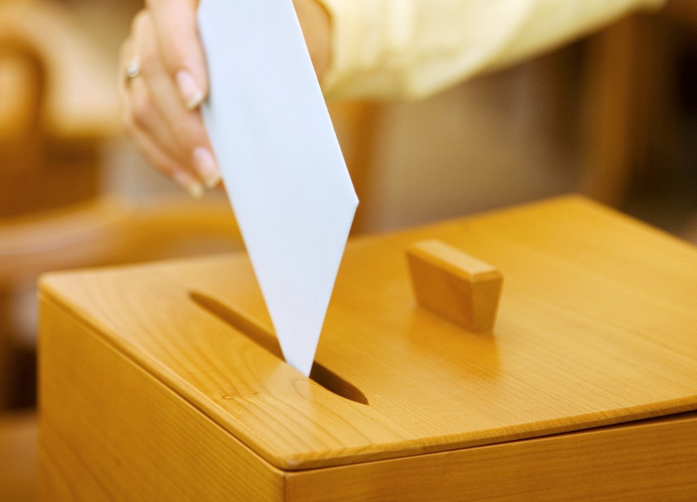 Frau bei Wahl mit Stimmzettel und Wahlurne / Erwin Wodicka Frau bei Wahl mit Stimmzettel und Wahlurne